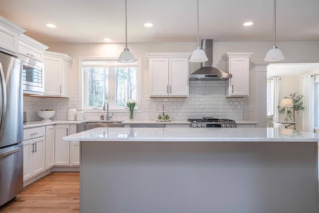 a large kitchen with granite countertop a sink stainless steel appliances and cabinets