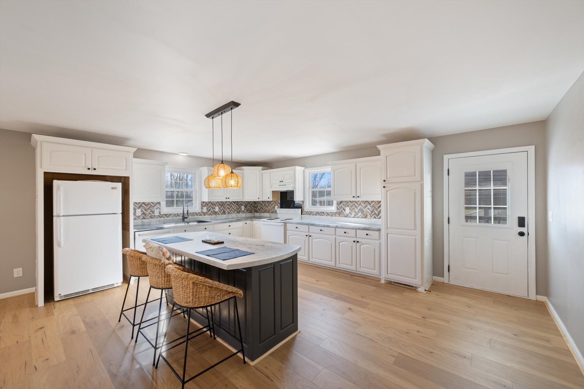 245 South Mill Street Linden, TN 37096 - Photo 7 of 30 a kitchen with a refrigerator a sink dishwasher a stove and a dining table with wooden floor