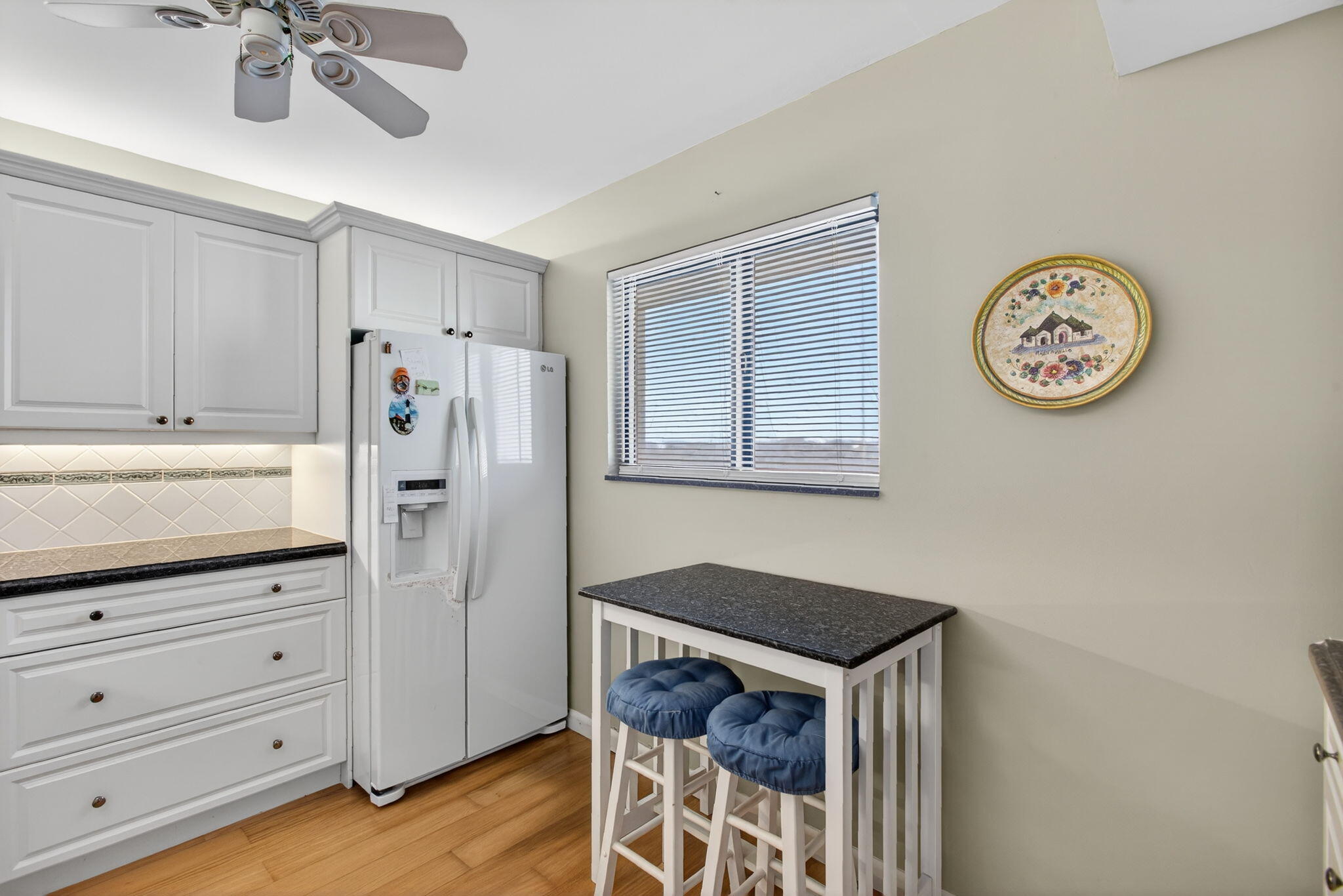 200 Ocean Trail Way, Unit 405 Jupiter, FL 33477 - Photo 14 of 46 a kitchen with white cabinets and wooden floor