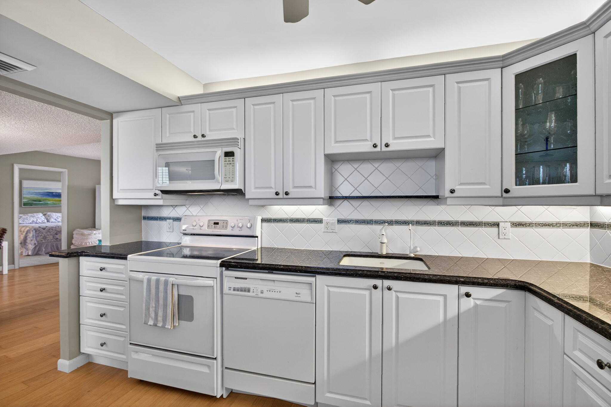 200 Ocean Trail Way, Unit 405 Jupiter, FL 33477 - Photo 16 of 46 a kitchen with white cabinets and sink