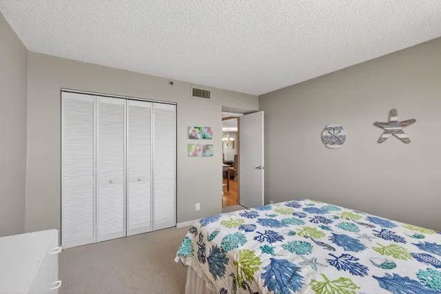 a bedroom with a bed flat screen tv and a large window