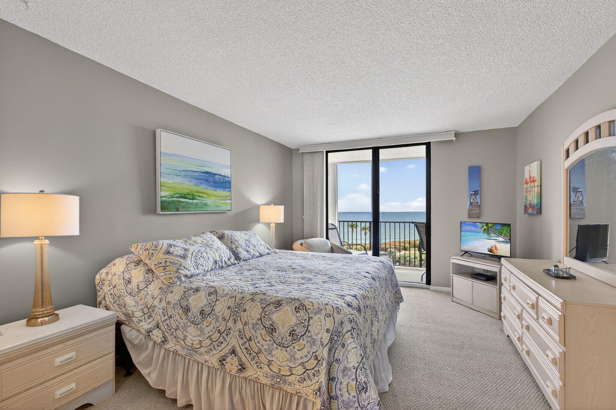 200 Ocean Trail Way, Unit 405 Jupiter, FL 33477 - Photo 21 of 46 a bedroom with a bed flat screen tv and a large window