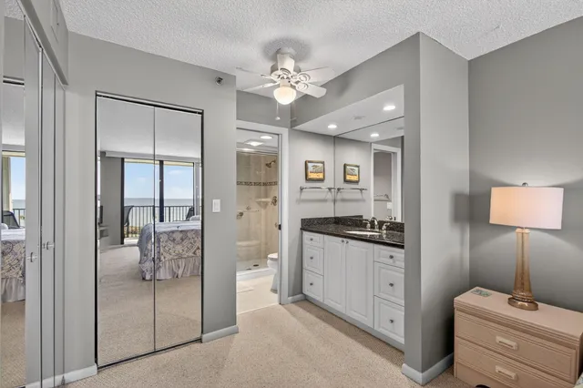 a bathroom with a granite countertop sink a large mirror and shower