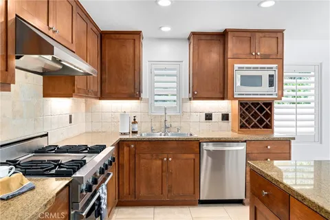 a kitchen with granite countertop a sink a stove and cabinets