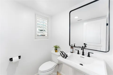 a bathroom with a sink toilet and mirror