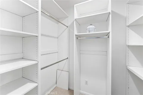 a view of walk in closet with empty racks