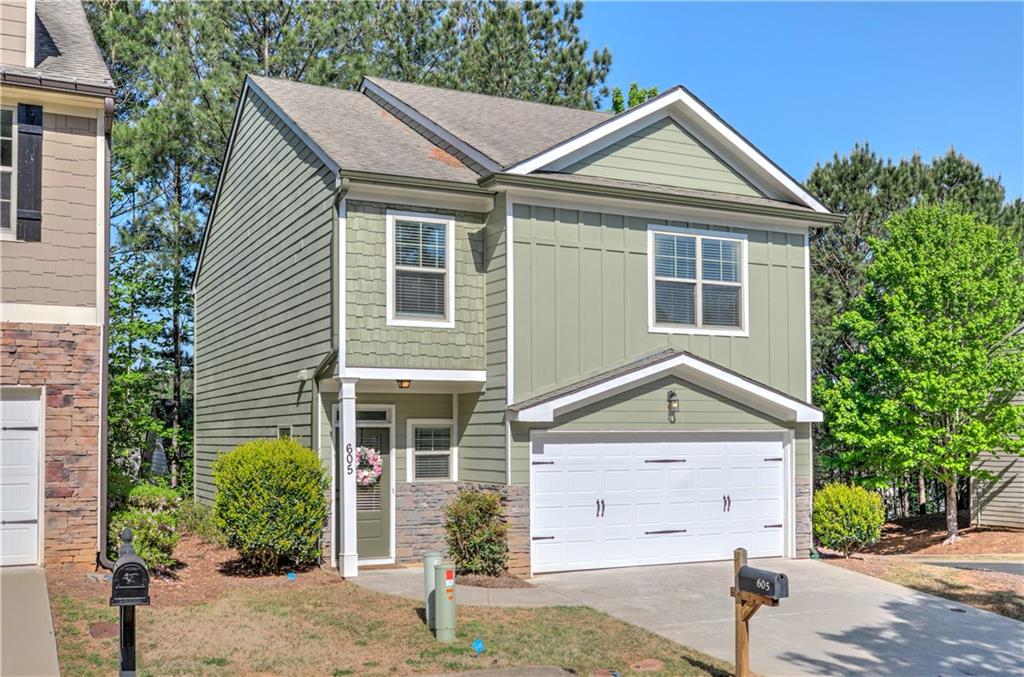 605 Summit Point Canton, GA 30114 - Photo 3 of 56 a front view of a house with a yard and garage
