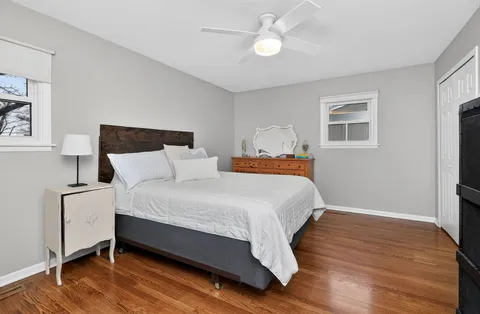 a bedroom with bed and wooden floor