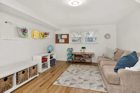 a living room with furniture and a baby crib