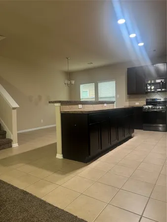a kitchen with stainless steel appliances granite countertop a sink a stove a microwave and a refrigerator
