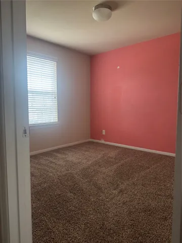an empty room with windows and fireplace