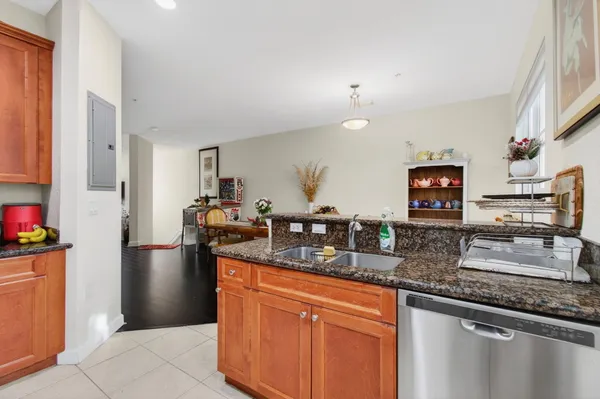 a kitchen with stainless steel appliances granite countertop a sink and a refrigerator