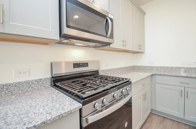 a kitchen with white cabinets and appliances