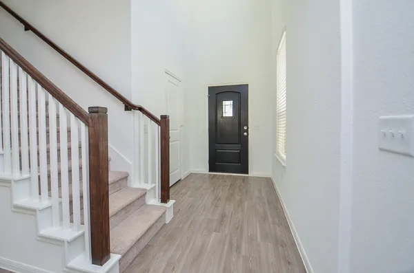 a view of a hallway with wooden floor and staircase