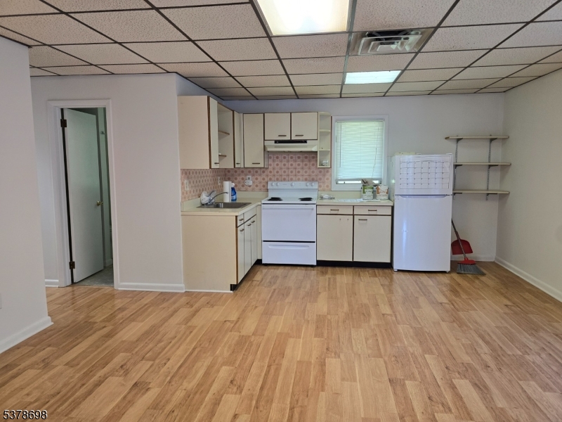 1 Highway 94, Unit E&F Vernon, NJ 07462 - Photo 3 of 4 a kitchen with a wooden floor and white stainless steel appliances