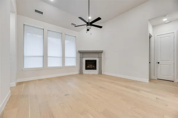 a view of an empty room with a fireplace and a window