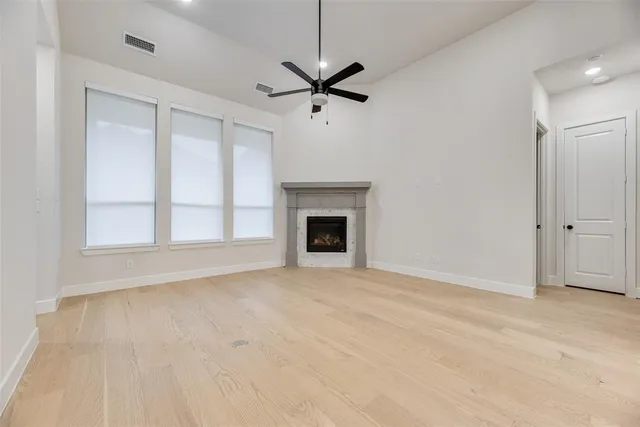 a view of an empty room with a fireplace and a window