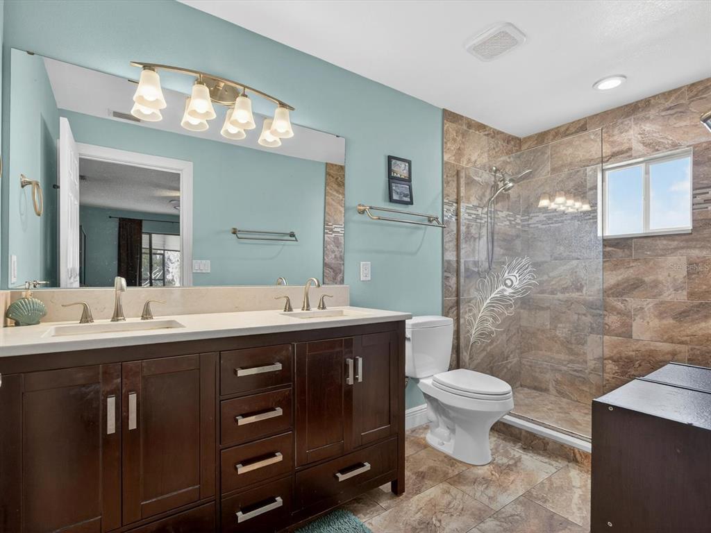 11321 Scenic View Lane Orlando, FL 32821 - Photo 16 of 29 a spacious bathroom with a granite countertop sink a toilet and a mirror