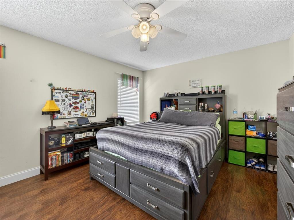 11321 Scenic View Lane Orlando, FL 32821 - Photo 10 of 29 a bedroom with a bed and a chandelier