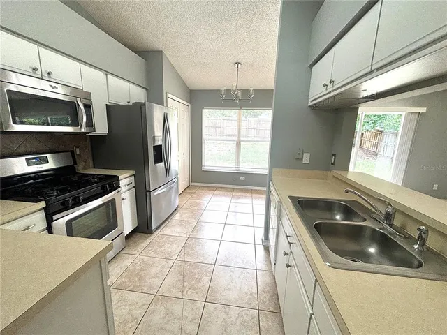 a kitchen with granite countertop a refrigerator and a sink