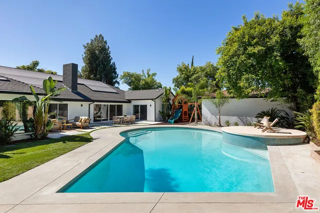 a view of house with swimming pool yard and outdoor seating