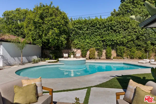 a view of a swimming pool with a patio and couches