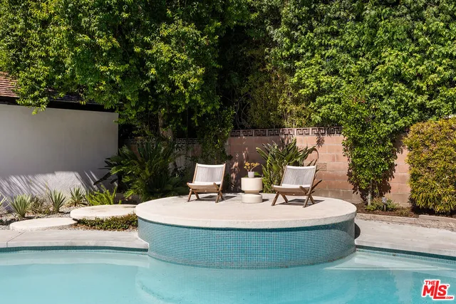 a view of a backyard with swimming pool