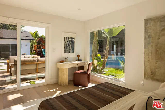 a bedroom with a bed a couch and potted plant