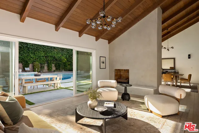 a living room with patio furniture and a flat screen tv