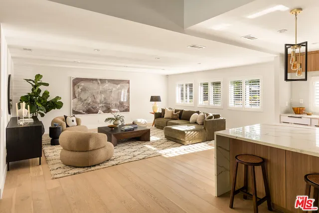a kitchen with stainless steel appliances a sink a counter top space and living room view