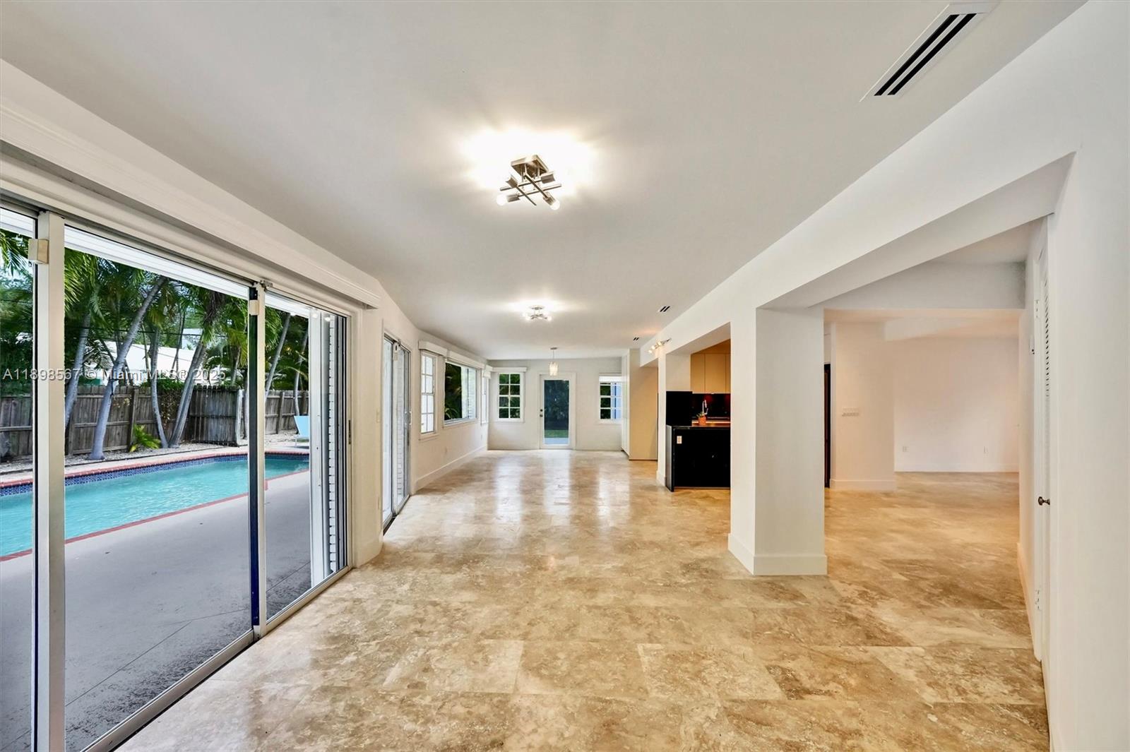 255 Ridgewood Road Key Biscayne, FL 33149 - Photo 11 of 55 a view of a hallway with an empty room and chandelier fan
