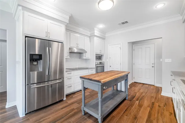 a kitchen with a table chairs sink and cabinets