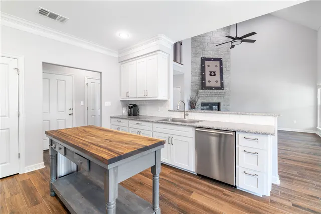 a kitchen with a sink window and wooden floor