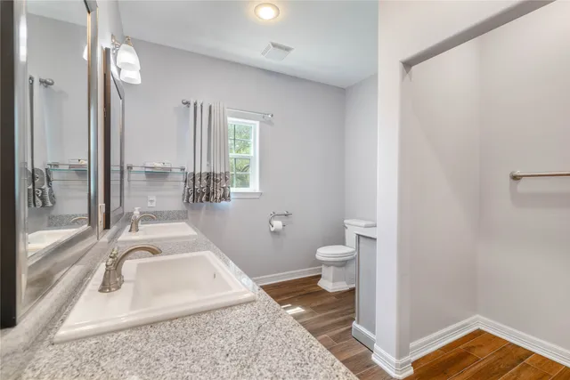 a bathroom with a granite countertop sink and a mirror