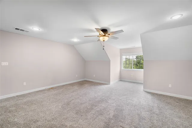 an empty room with a ceiling fan and window