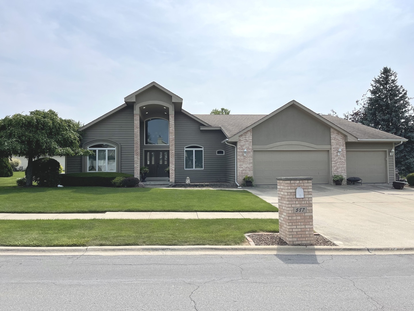 a front view of a house with a yard and trees