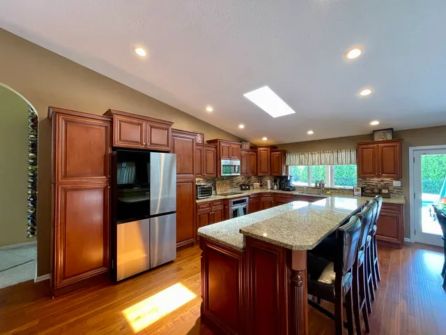 a kitchen with stainless steel appliances granite countertop a sink stove and cabinets