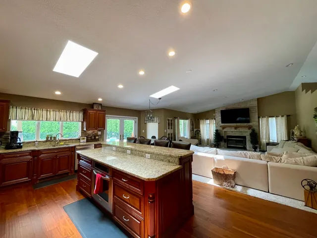 a kitchen with stainless steel appliances granite countertop a sink refrigerator and cabinets
