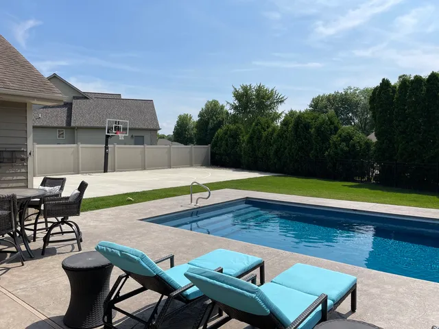 an outdoor space with swimming pool and furniture