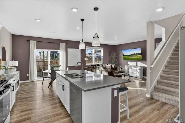 a kitchen with sink stove and wooden floor