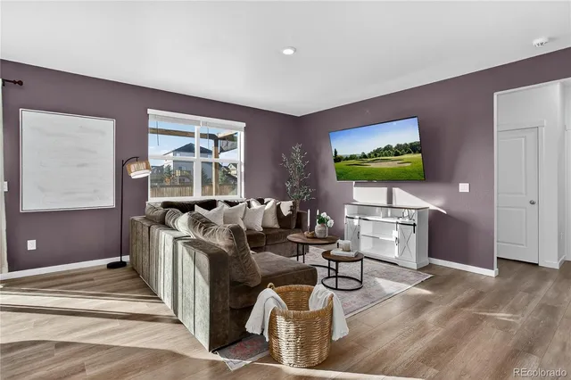 a living room with furniture a window and a flat screen tv