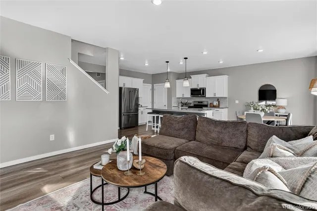 a living room with furniture kitchen view and a potted plant