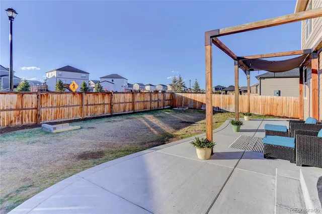 a view of a terrace with couches and wooden fence