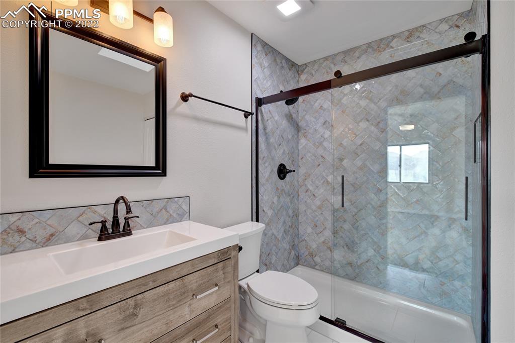 9 Sutherland Road Manitou Springs, CO 80829 - Photo 24 of 31 a bathroom with a sink mirror toilet and next to a window