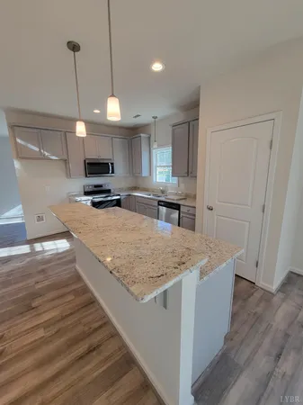 a kitchen with kitchen island a counter top space appliances and cabinets