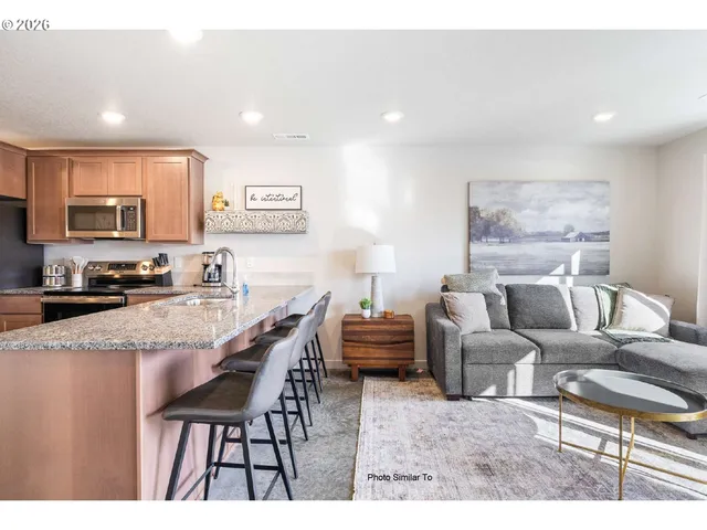 a living room with furniture a flat screen tv and a table