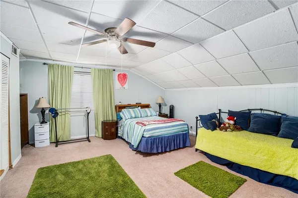 a spacious bedroom with two beds and a rug