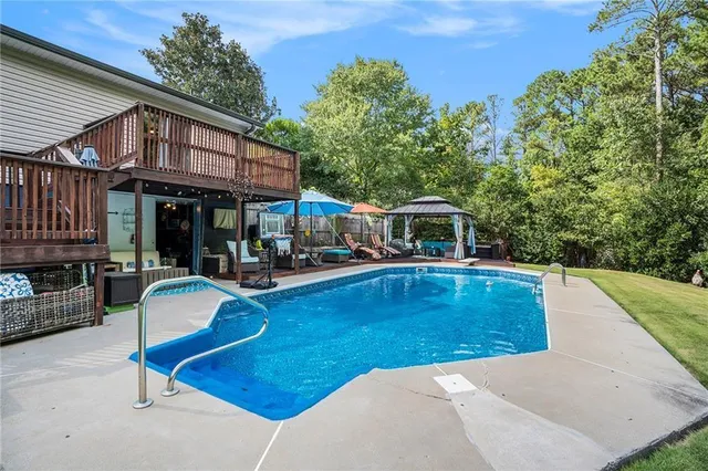swimming pool view with a seating space and a garden view