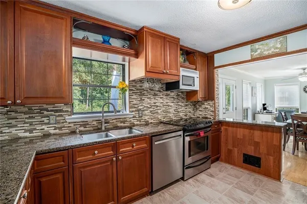 a kitchen with stainless steel appliances granite countertop a sink stove and cabinets