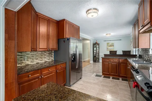 a kitchen with stainless steel appliances granite countertop a refrigerator and a stove top oven